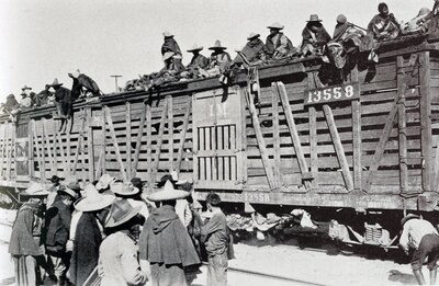 "Mexican Troop Train Somewhere in Mexico—Horses in Enclosed Section of Cars and Women and Children Riding the Brakebeams"