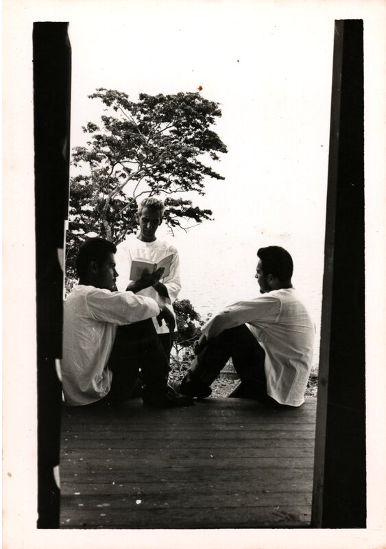 Ernesto Cardenal reading with two community members listening