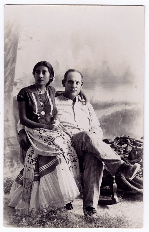 Portrait of a woman from Tehuantepec sitting next to a Caucasian man